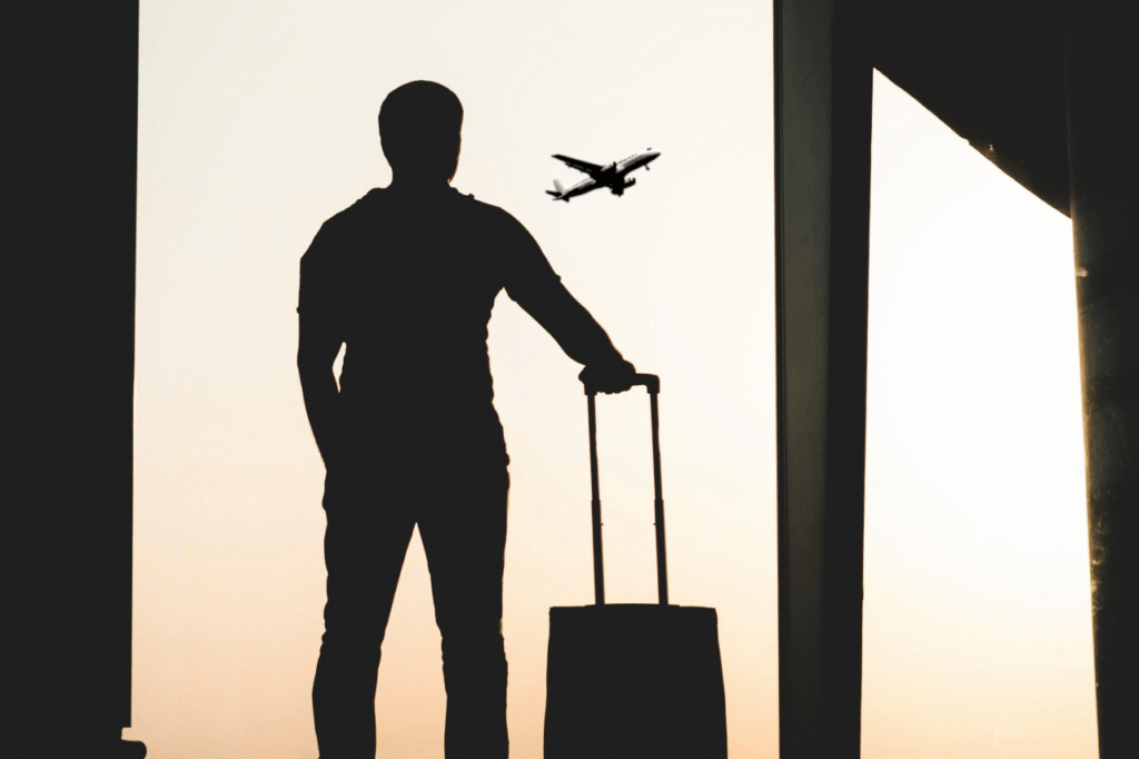 Traveler with luggage watching a plane at the airport before an Aurora Pursuit transfer